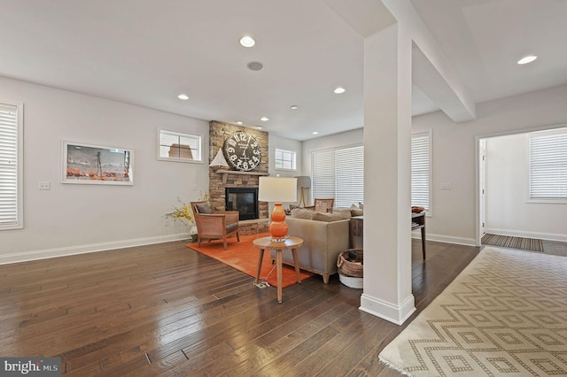 living room featuring dark wood-style floors, baseboards, a fireplace, and recessed lighting