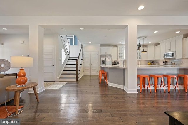 interior space with dark wood-type flooring, stairway, baseboards, and recessed lighting