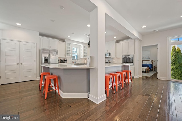 kitchen with white cabinets, a kitchen bar, and stainless steel appliances