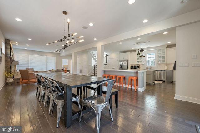 dining room featuring stairs, recessed lighting, dark wood-type flooring, baseboards, and a notable chandelier