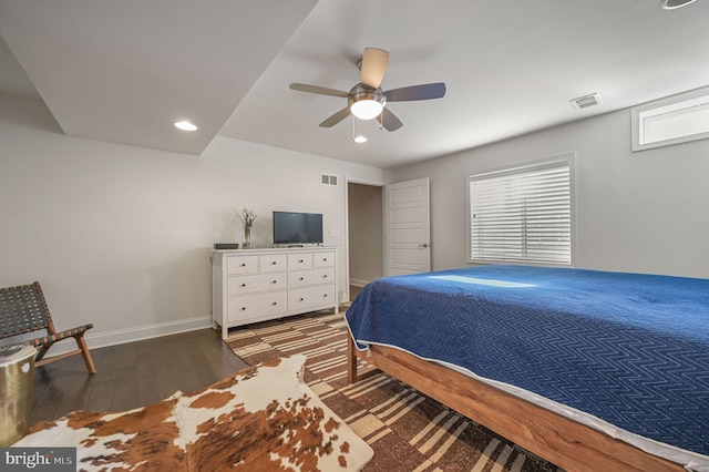 bedroom featuring baseboards, ceiling fan, visible vents, and wood finished floors