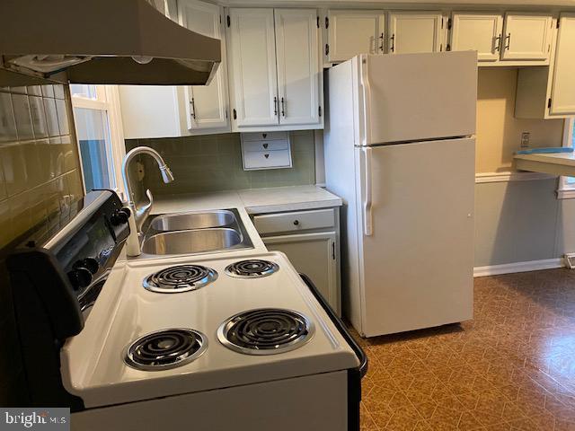 1095 Senseny Rd, Berryville, VA 22611 - kitchen with a sink, white appliances, light countertops, tasteful backsplash, and under cabinet range hood