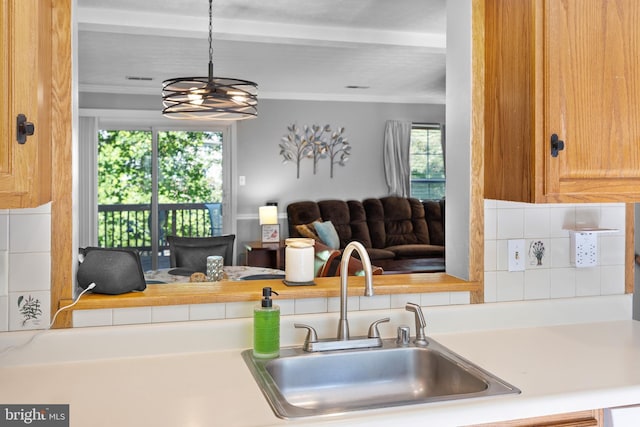 458 Silver Ct, Westminster, MD 21158 - kitchen featuring a sink, light countertops, open floor plan, ornamental molding, and a chandelier
