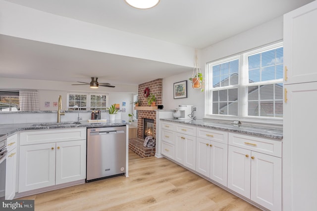 219 Hitching Post Dr, Bel Air, MD 21014 - kitchen featuring dishwasher, a sink, light wood finished floors, white cabinetry, and a brick fireplace