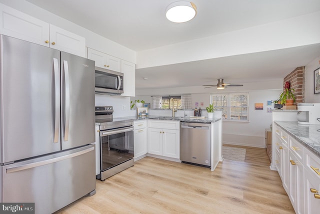 219 Hitching Post Dr, Bel Air, MD 21014 - kitchen with stainless steel appliances, a peninsula, white cabinetry, and light wood-style flooring