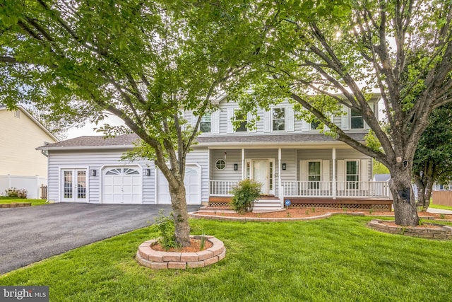 view of front facade with french doors, covered porch, driveway, and a front lawn