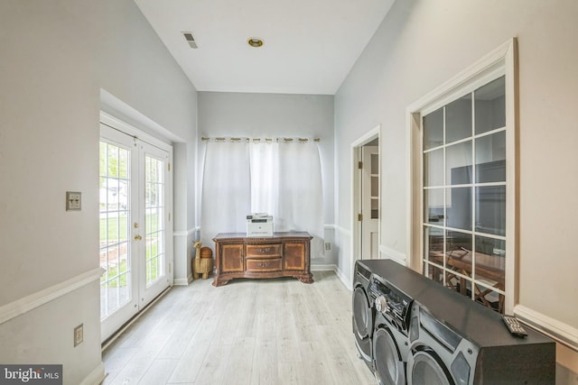 doorway with a wealth of natural light, french doors, light wood-type flooring, and washing machine and clothes dryer
