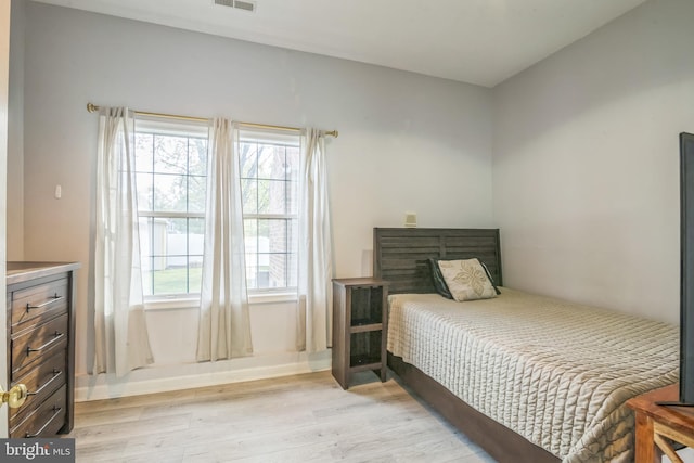 bedroom featuring baseboards, visible vents, multiple windows, and light wood-style flooring