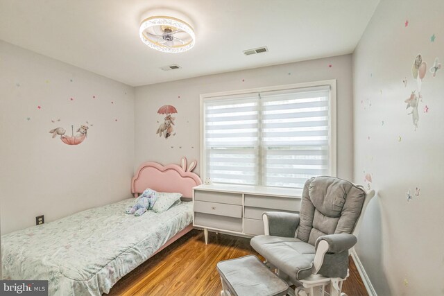bedroom featuring visible vents and wood finished floors