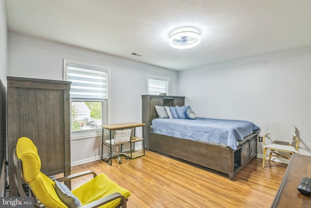 bedroom with light wood-style floors, baseboards, and visible vents