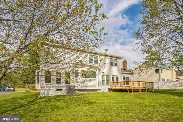 back of property with a yard, fence, a wooden deck, and a chimney