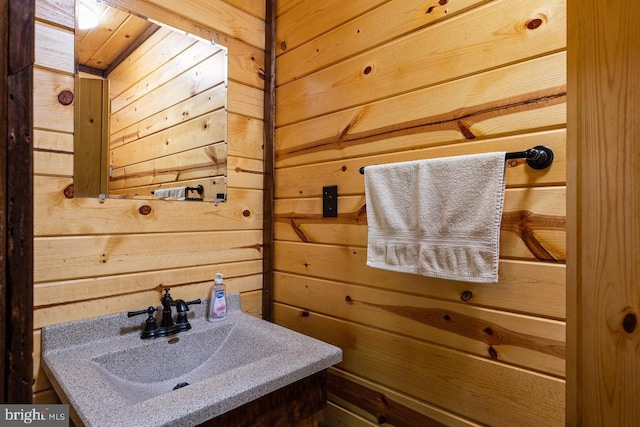bathroom with wood walls and a sink