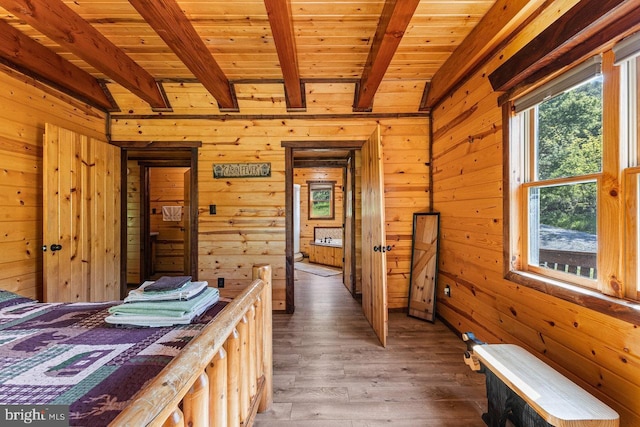 bedroom featuring wood ceiling, wood walls, hardwood / wood-style flooring, and beam ceiling