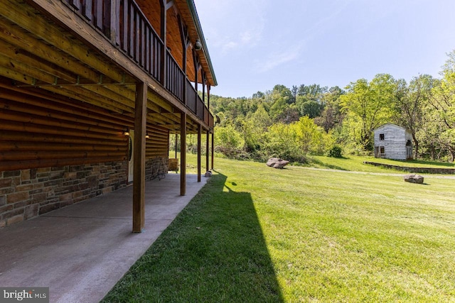 view of yard featuring a view of trees and a patio area