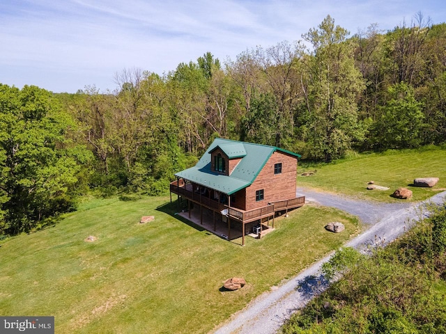 drone / aerial view featuring a wooded view
