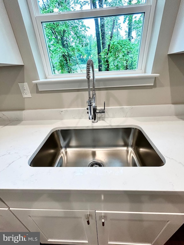 4655 Mountain Rd, Pasadena, MD 21122 - kitchen view of a sink, white cabinets, and light stone counters