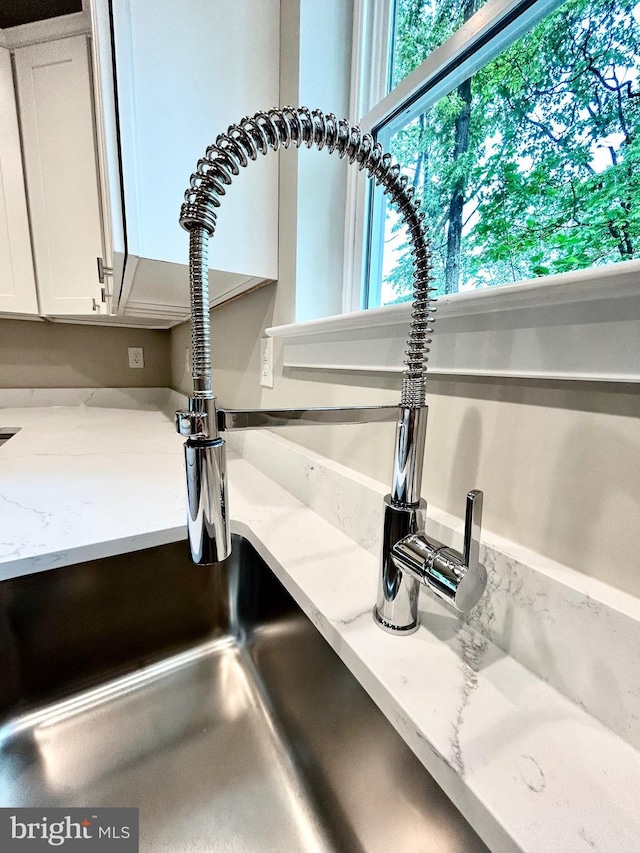 4655 Mountain Rd, Pasadena, MD 21122 - kitchen view of a sink, white cabinetry, and light stone counters