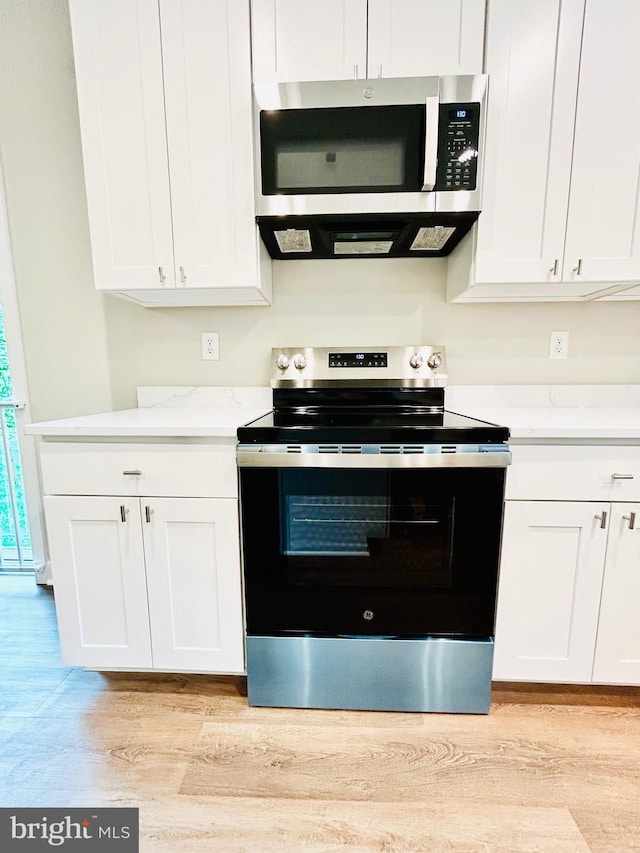 4655 Mountain Rd, Pasadena, MD 21122 - kitchen with stainless steel appliances, light wood finished floors, and white cabinetry