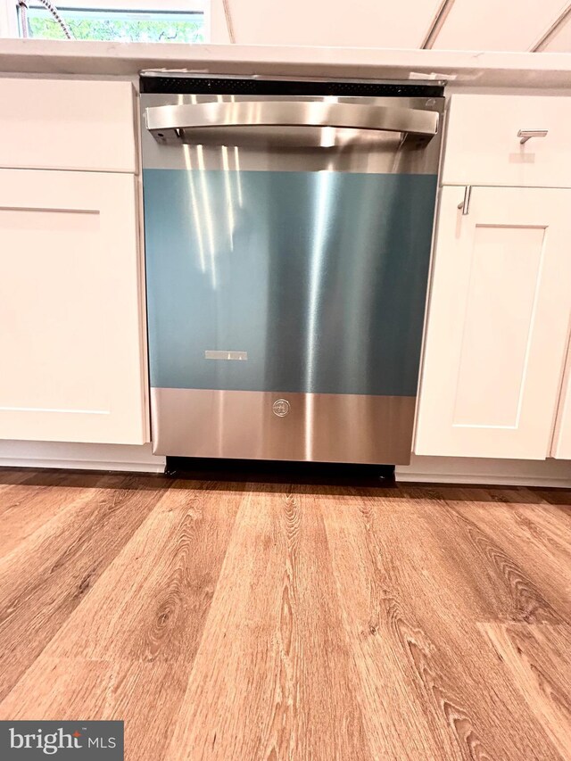 4655 Mountain Rd, Pasadena, MD 21122 - detailed view of dishwasher, white cabinetry, and wood finished floors