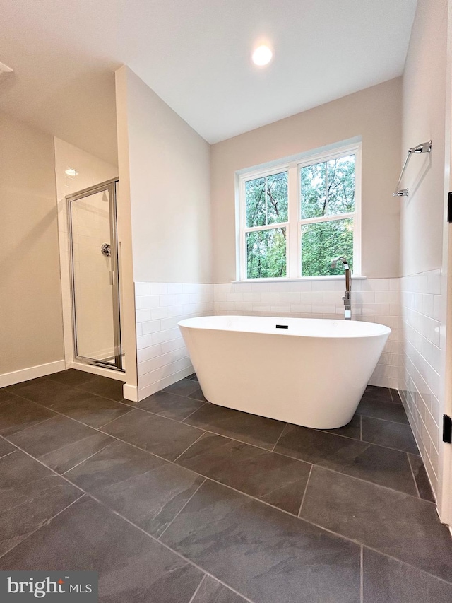4655 Mountain Rd, Pasadena, MD 21122 - bathroom featuring tile walls, a stall shower, a soaking tub, a wainscoted wall, and tile patterned floors