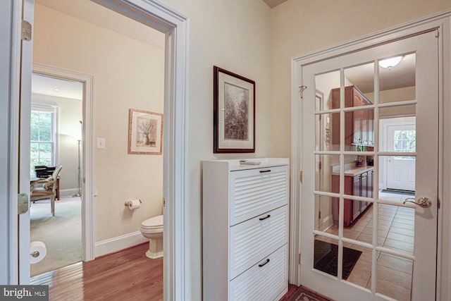 bathroom featuring toilet, wood finished floors, and baseboards