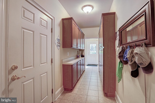 corridor featuring baseboards and light tile patterned floors