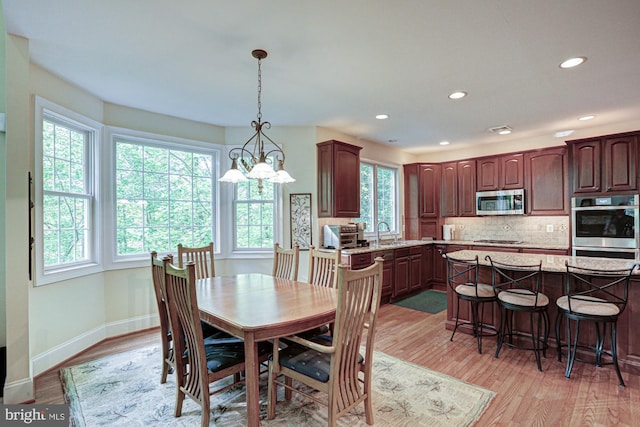 dining room featuring light wood-style flooring, recessed lighting, and baseboards