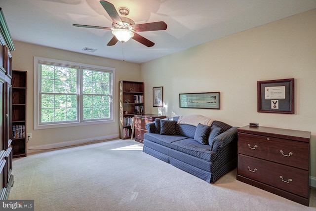 living room featuring light carpet, a ceiling fan, and baseboards