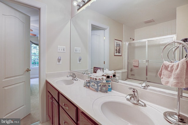 full bathroom featuring a shower with door and double vanity