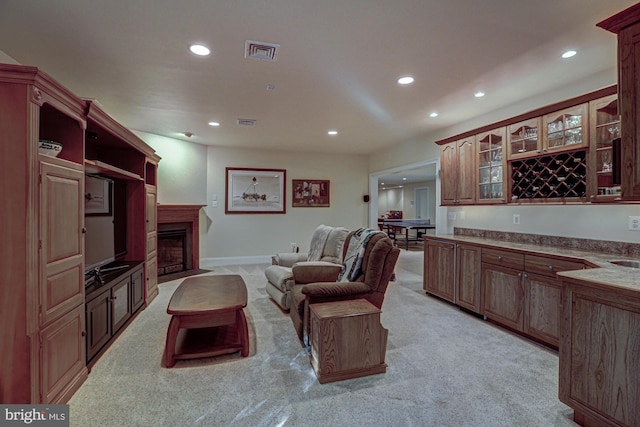 living area featuring recessed lighting, light colored carpet, a fireplace, and baseboards