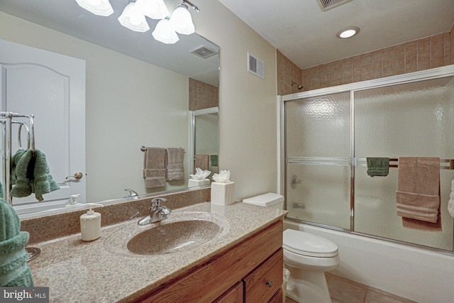 bathroom featuring vanity, tile patterned floors, combined bath / shower with glass door, toilet, and a chandelier