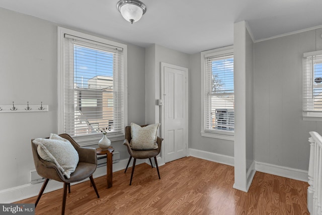living area with baseboards and wood finished floors
