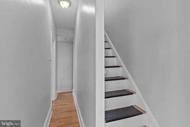 stairway with wood finished floors and baseboards
