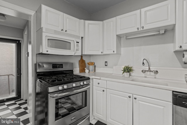 kitchen featuring white cabinetry, tile patterned floors, stainless steel appliances, and light countertops