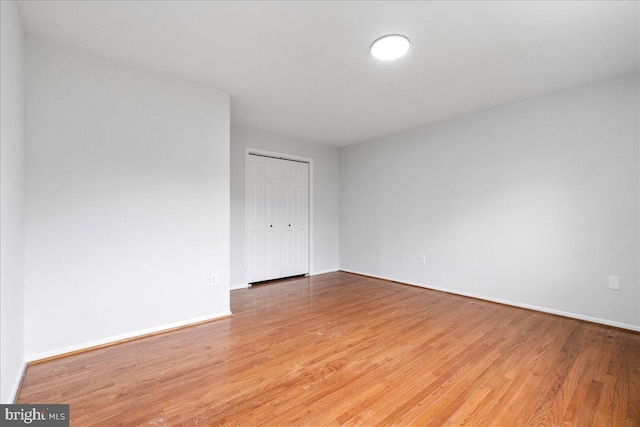 spare room featuring baseboards and wood finished floors
