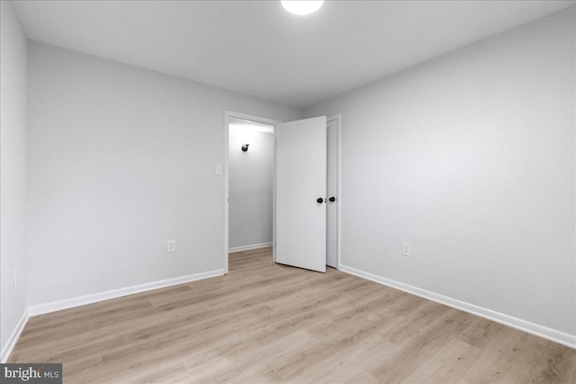 unfurnished room with baseboards and light wood-style floors