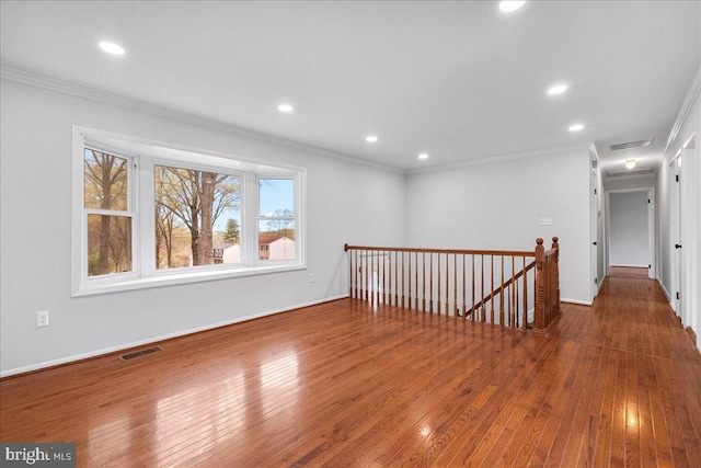 spare room with visible vents, ornamental molding, and hardwood / wood-style floors