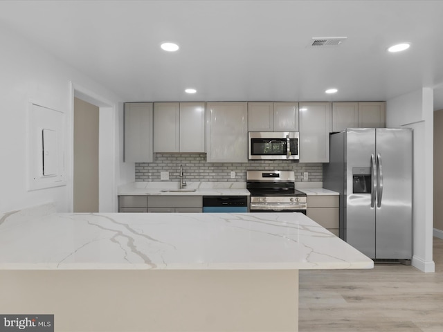 6301 Stevenson Ave Unit 310, Alexandria, VA 22304 - kitchen featuring stainless steel appliances, gray cabinets, decorative backsplash, light stone counters, and recessed lighting