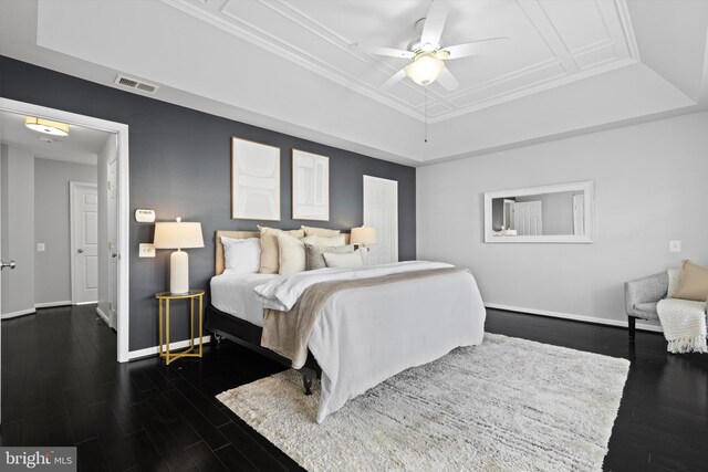 bedroom with a tray ceiling, baseboards, dark wood-style flooring, and ceiling fan