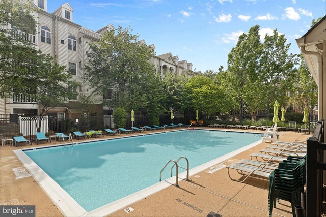 community pool with fence and a patio