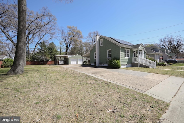 view of property exterior featuring a garage, an outbuilding, a chimney, and a lawn