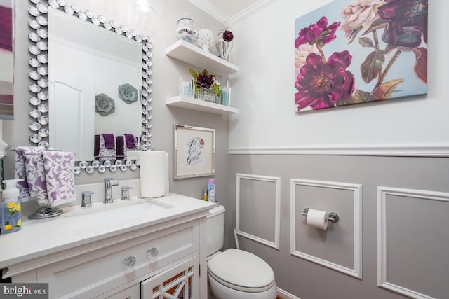 bathroom featuring crown molding, toilet, and vanity