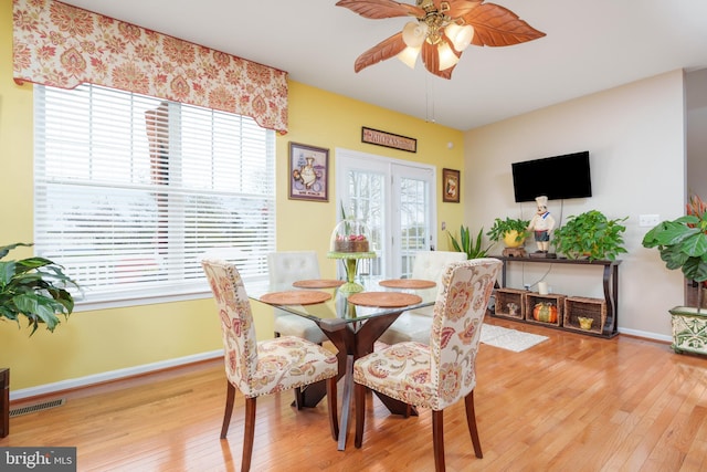 dining area with wood-type flooring, visible vents, baseboards, and a ceiling fan