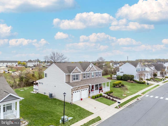 traditional home with a front lawn, a residential view, a garage, and central air condition unit