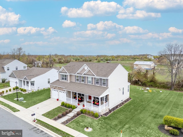 view of front of property with covered porch, roof with shingles, a front lawn, a garage, and concrete driveway