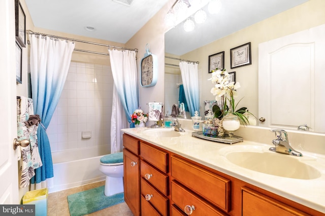 full bathroom with tile patterned floors, double vanity, a sink, and toilet