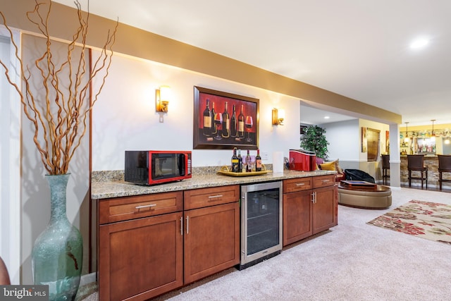 bar featuring beverage cooler, bar area, and light carpet