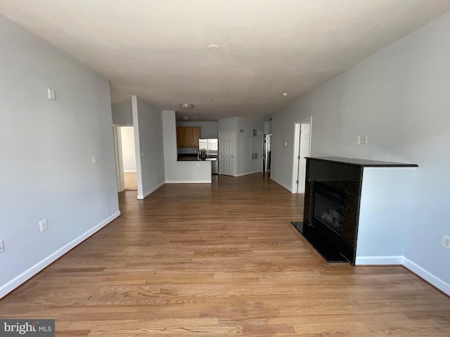 42480 Rockrose Sq Unit 202, Brambleton, VA 20148 - unfurnished living room featuring light wood-style flooring, baseboards, and a fireplace