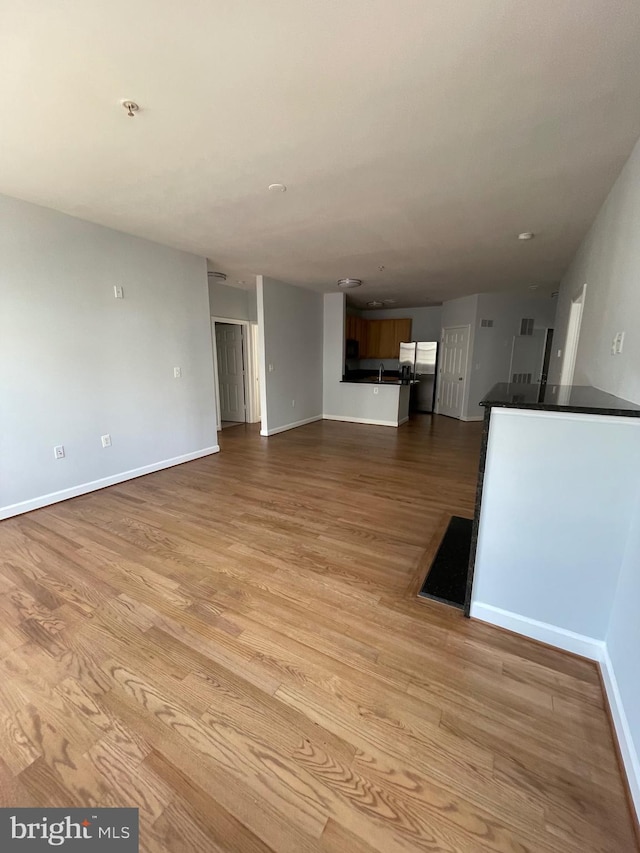 42480 Rockrose Sq Unit 202, Brambleton, VA 20148 - unfurnished living room with light wood-type flooring and baseboards