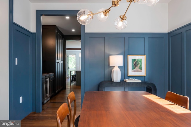 dining space featuring a decorative wall and dark wood finished floors